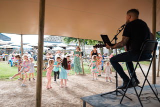 Kids dancing to live music under a large tent at Cotswold Farm Park